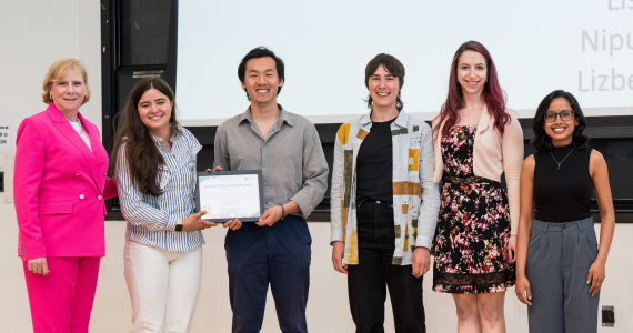 A group of students with an adminstrator standing on stage to accept an award